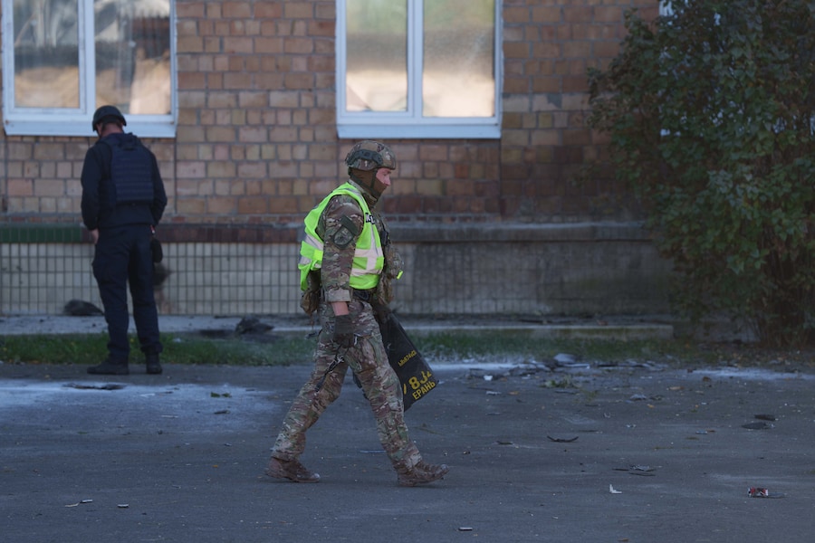 Un agente di polizia trasporta i frammenti di un drone Shahed davanti a una scuola danneggiata da un attacco russo a Kiev, in Ucraina, giovedì 1 ottobre 2026. (APN)