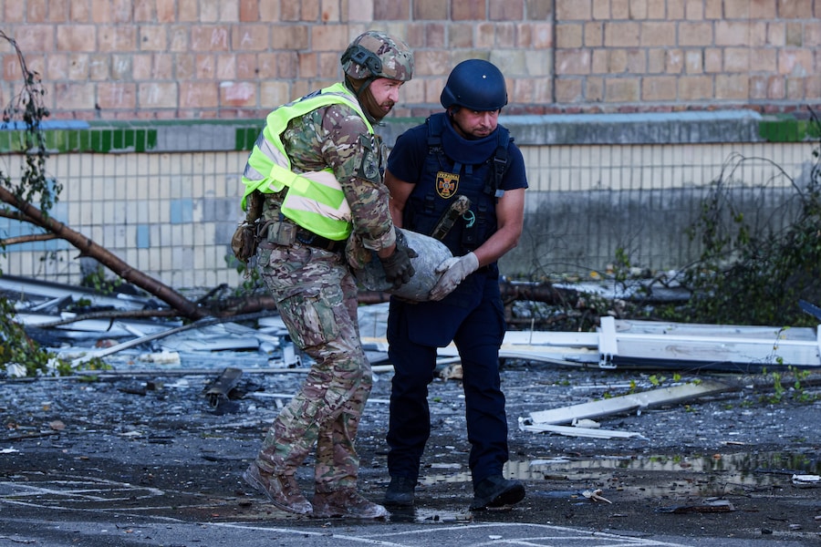 Un agente di polizia e un soccorritore trasportano una testata inesplosa proveniente da un drone Shahed fuori da una scuola colpita da un attacco russo a Kiev, in Ucraina, giovedì 1 ottobre 2026. (APN)