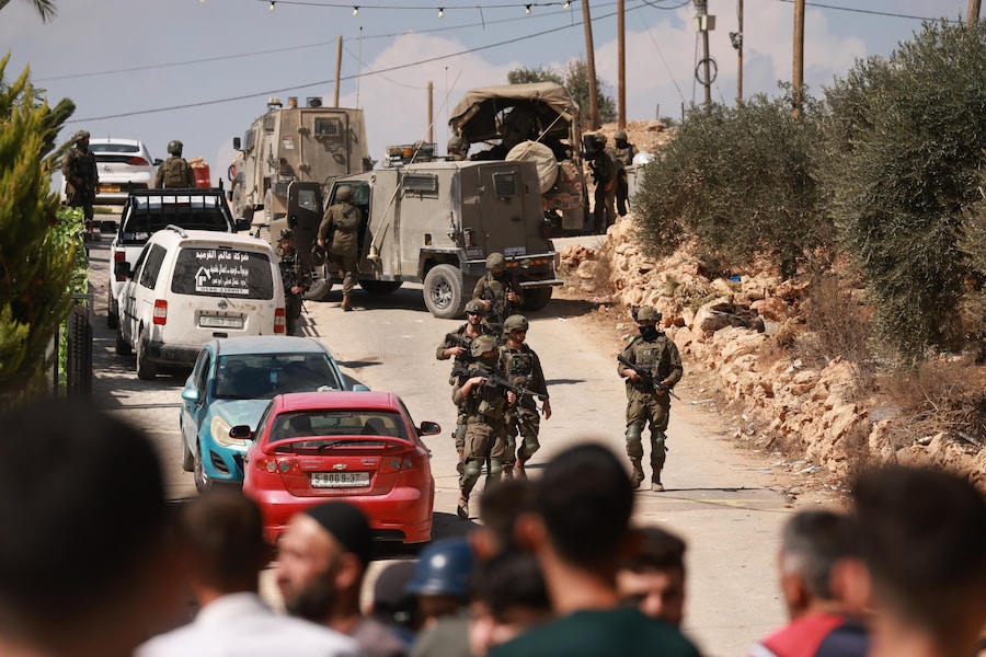 Soldati israeliani pattugliano una strada dopo un attacco da parte di coloni israeliani nel villaggio di Osarin, a sud di Nablus, in Cisgiordania (EPA)