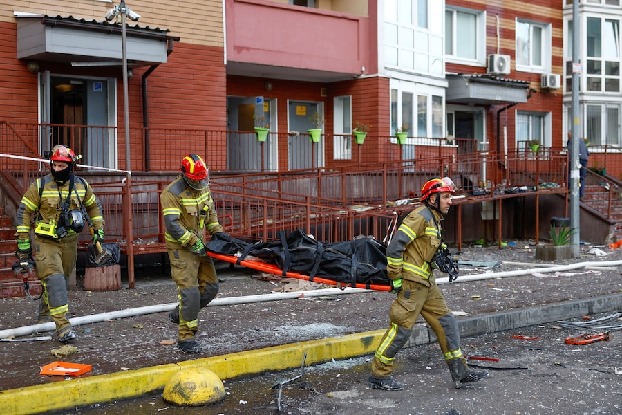 I soccorritori trasportano il corpo di un residente rimasto ucciso all'interno di un condominio durante un attacco con droni russi a Kiev (REUTERS)