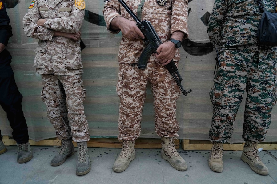 Uomini appartenenti alla Guardia Rivoluzionaria in piedi durante la cerimonia di inaugurazione di uno dei centri di addestramento militare per volontari che vengono allestiti nelle piazze del centro di Teheran, in Iran (APN)