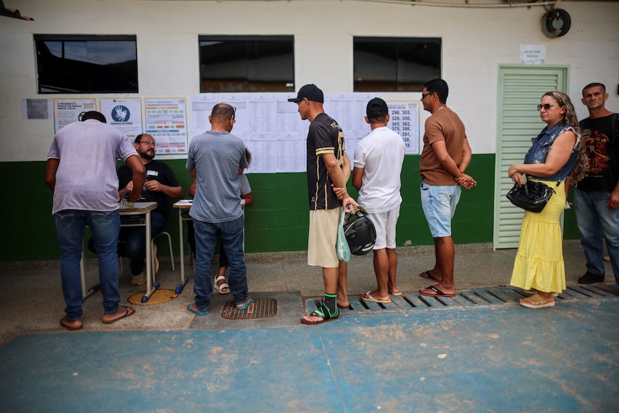 La gente fa la fila per votare durante le elezioni generali brasiliane in un seggio elettorale situato in una scuola a Vila Estrutural, alla periferia di Brasilia, in Brasile. (REUTERS)