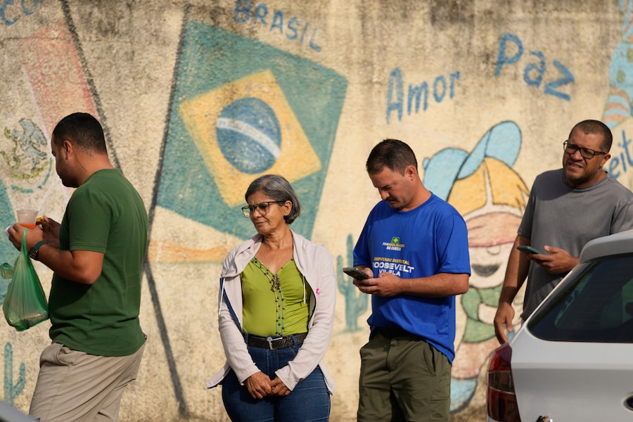 Gli elettori fanno la fila davanti a un seggio elettorale durante le elezioni generali a Brasilia, Brasilia. (APN)