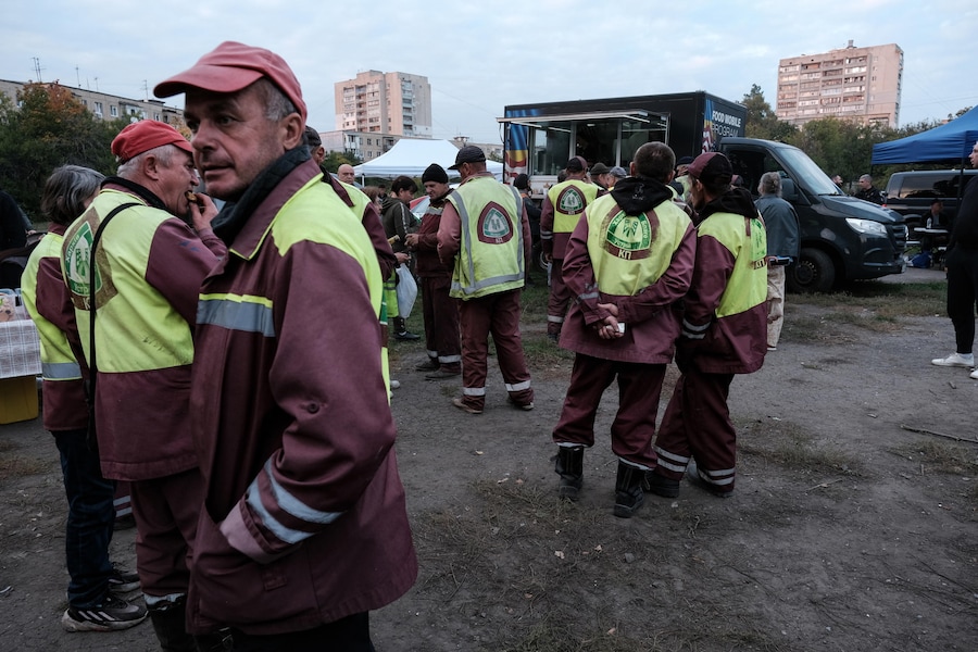 Alcuni volontari si concedono una pausa durante le operazioni di pulizia nell’area colpita da un bombardamento russo a Kharkiv, in Ucraina, il 5 ottobre 2026. (EPA)