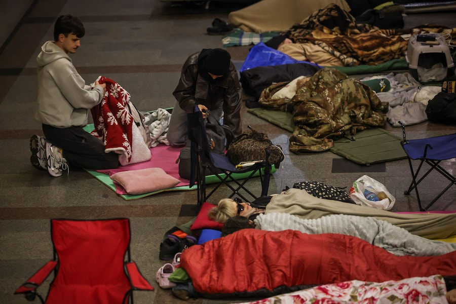 Una coppia sistema il proprio letto di fortuna all’interno di una stazione della metropolitana, dove si è rifugiata insieme ad altri residenti durante un attacco missilistico russo, nel contesto dell’offensiva russa contro l’Ucraina, a Kiev. (REUTERS)