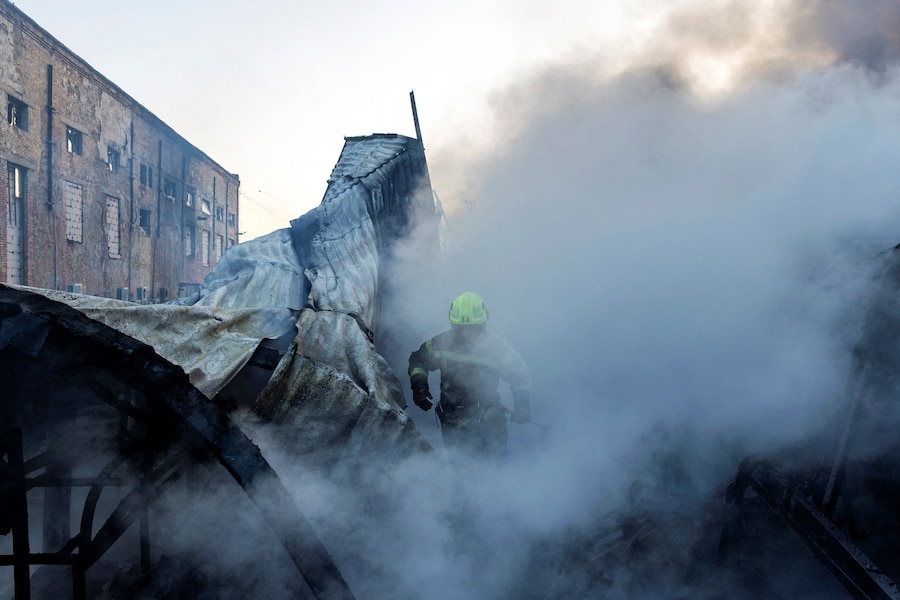 Un pompiere cammina tra il fumo sul luogo di un magazzino completamente distrutto da un incendio dopo essere stato colpito durante una notte di attacchi missilistici russi, nel contesto dell'offensiva russa contro l'Ucraina, a Kiev. (REUTERS)