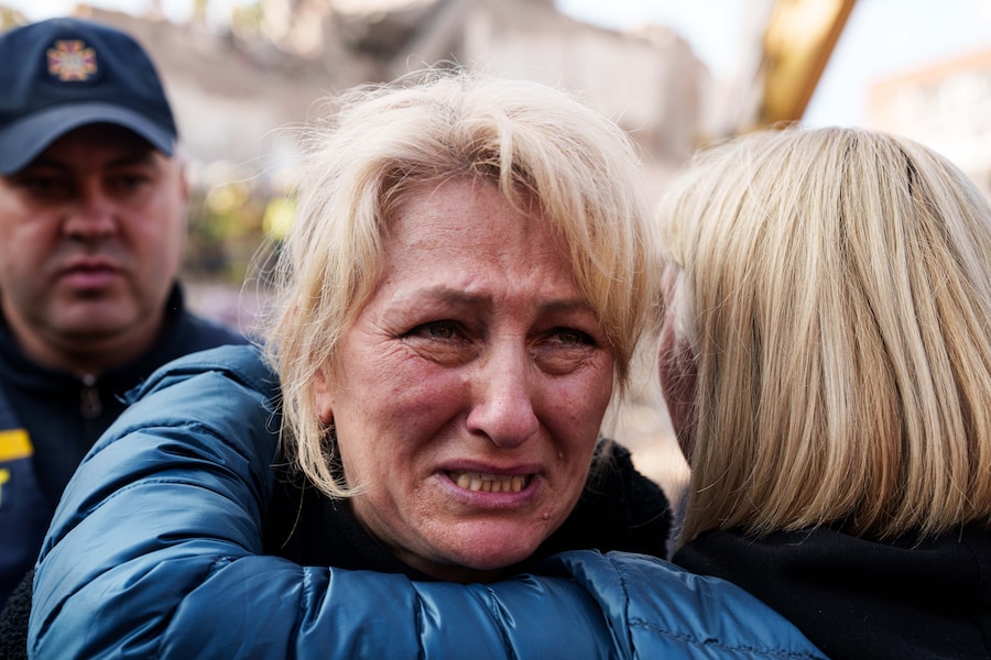 Una donna reagisce mentre si trova accanto a un edificio residenziale distrutto da un attacco missilistico russo a Pryluky. (APN)