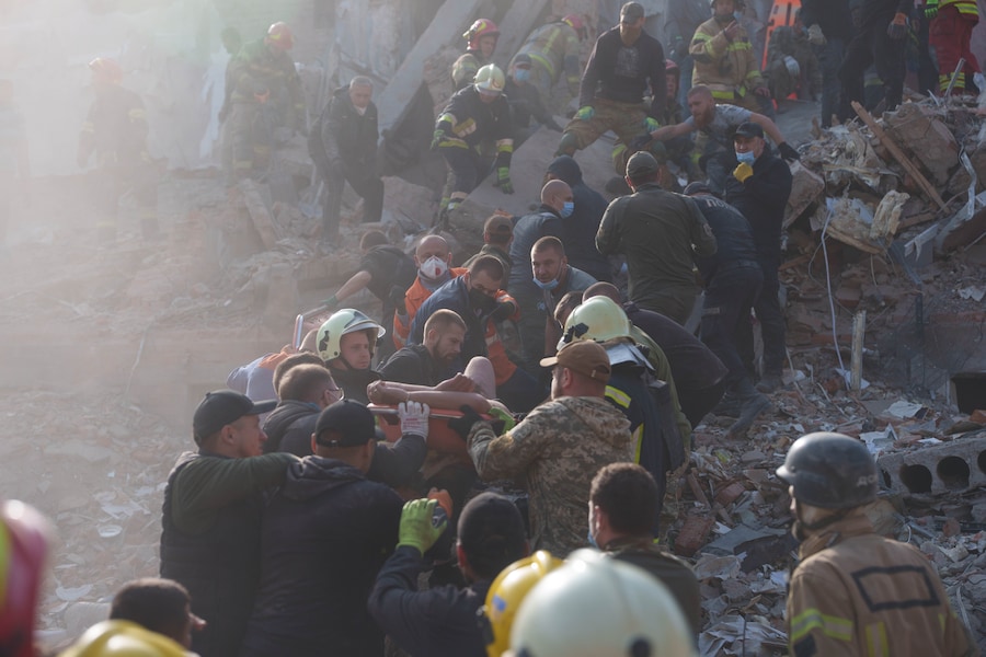 Mercoledì 7 ottobre 2026, a Pryluky, in Ucraina, alcuni residenti e soccorritori trasportano un uomo ferito fuori da un edificio residenziale distrutto da un attacco missilistico russo. (APN)