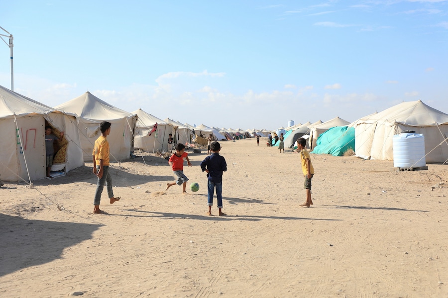 Dei ragazzi giocano a calcio in un campo improvvisato per sfollati a causa degli scontri tra i combattenti Houthi, alleati dell’Iran, e le forze governative yemenite sostenute dall’Arabia Saudita, nei pressi di Aden, nello Yemen, l’8 ottobre 2026. REUTERS/Stringer (REUTERS)