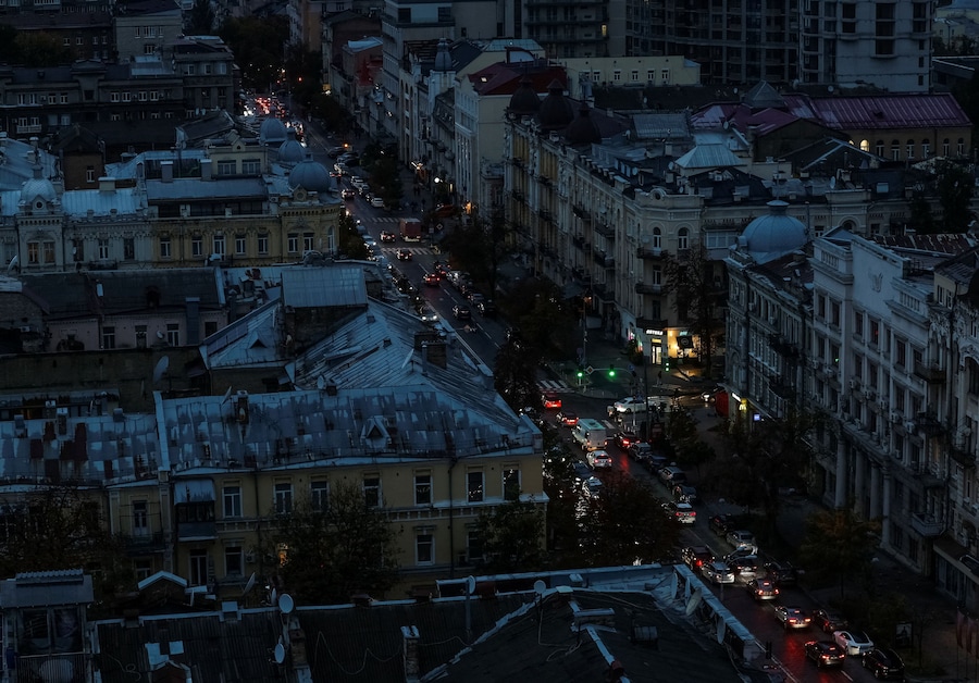 Alcune auto percorrono una strada buia fiancheggiata da edifici durante un blackout elettrico causato dagli attacchi russi con missili e droni contro infrastrutture civili strategiche, nel contesto dell’offensiva russa contro l’Ucraina, a Kiev, Ucraina, il 9 ottobre 2026. REUTERS/Gleb Garanich (REUTERS)