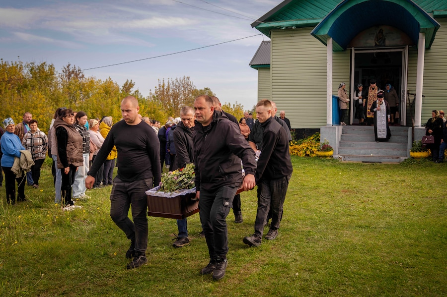 Venerdì 9 ottobre 2026, a Pryluky, nella regione di Chernihiv, in Ucraina, gli addetti alle pompe funebri trasportano le bare dei familiari rimasti uccisi in un attacco missilistico contro un edificio residenziale avvenuto il 7 ottobre, durante il loro funerale. (AP Photo/Dan Bashakov) (APN)