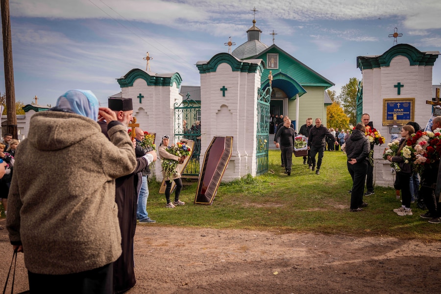 Gli addetti alle pompe funebri trasportano le bare di quattro membri di una stessa famiglia rimasti uccisi in un attacco missilistico contro un edificio residenziale il 7 ottobre, durante il loro funerale a Pryluky, nella regione di Chernihiv, in Ucraina, venerdì 9 ottobre 2026. (AP Photo/Dan Bashakov) (APN)