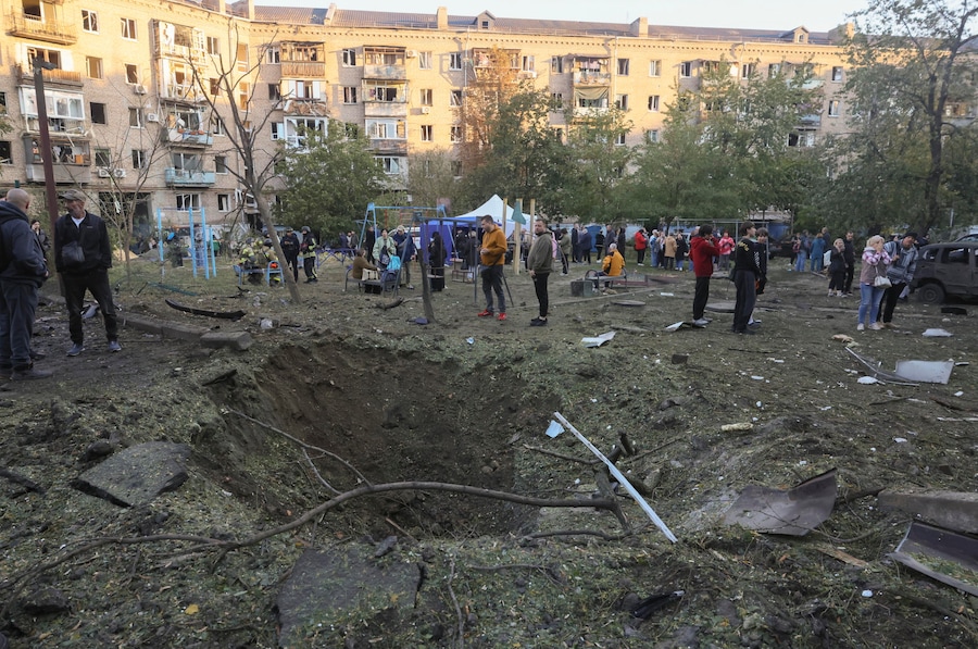 Alcuni residenti si trovano vicino a un cratere provocato da una bomba nel luogo in cui la Russia ha sferrato un attacco contro una zona residenziale a Zaporizhzhia, in Ucraina, il 9 ottobre 2026, nel contesto dell’invasione russa ancora in corso. Secondo quanto riportato dal Servizio statale di emergenza, almeno una persona è morta e altre otto sono rimaste ferite durante gli attacchi notturni russi con bombe plananti contro una zona residenziale di Zaporizhzhia. EPA/OLEG MOVCHANIUK (EPA)