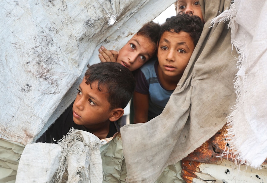Bambini palestinesi sbirciano dal luogo in cui si è verificato un attacco israeliano contro una tenda a Khan Younis, nella parte meridionale della Striscia di Gaza (REUTERS)