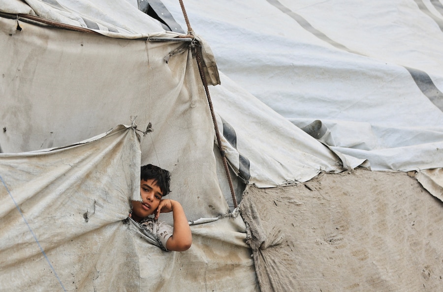 Un bambino palestinese guarda fuori da una tenda in un campo profughi, nella città di Gaza (REUTERS)