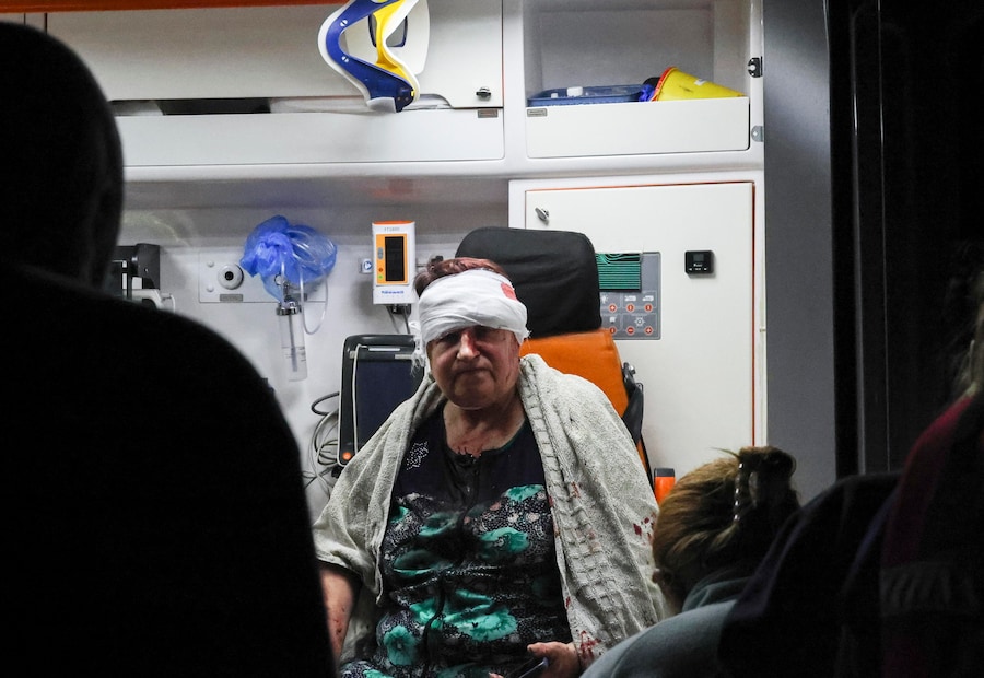 Una donna del posto ferita è seduta all’interno di un’ambulanza sul luogo di un attacco missilistico russo contro un negozio in una zona residenziale della città di Pisochyn, nella regione di Kharkiv, nel nord-est dell’Ucraina (EPA)