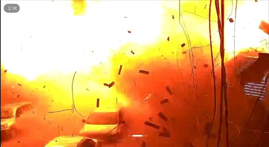 Le immagini delle telecamere di sorveglianza mostrano veicoli parcheggiati in una strada mentre cadono detriti a seguito di un'esplosione causata da un attacco russo a Kharkiv, Ucraina (via REUTERS)