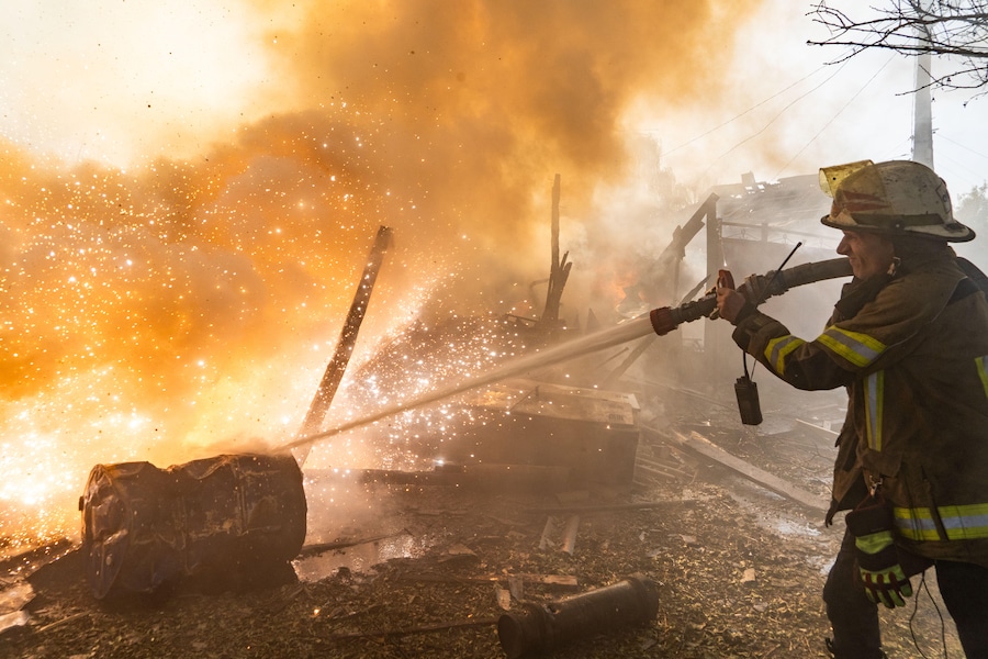 Un soccorritore spegne un incendio in alcune abitazioni distrutte da un attacco russo a Kharkiv, in Ucraina (APN)