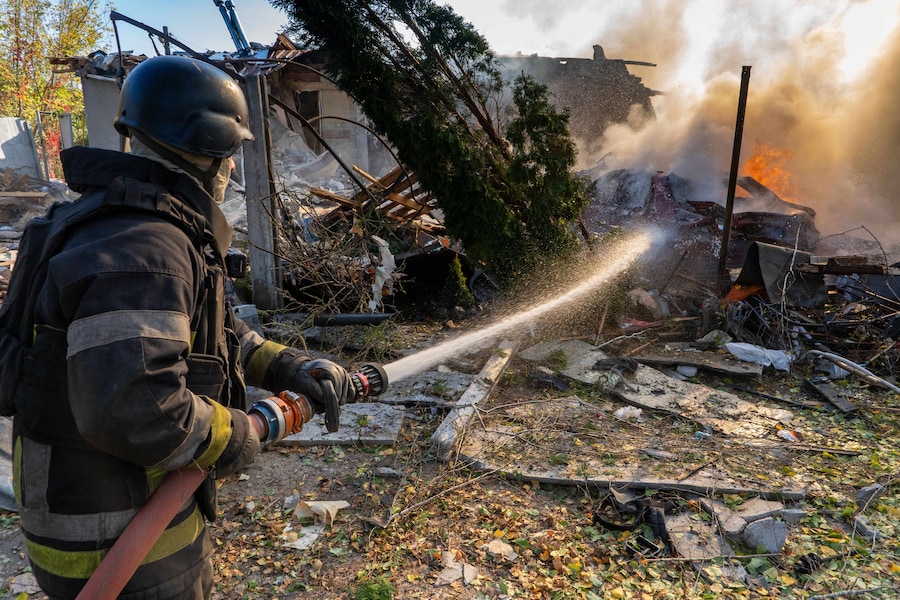 Un soccorritore spegne un incendio nelle abitazioni distrutte da un attacco russo a Kharkiv, in Ucraina (APN)