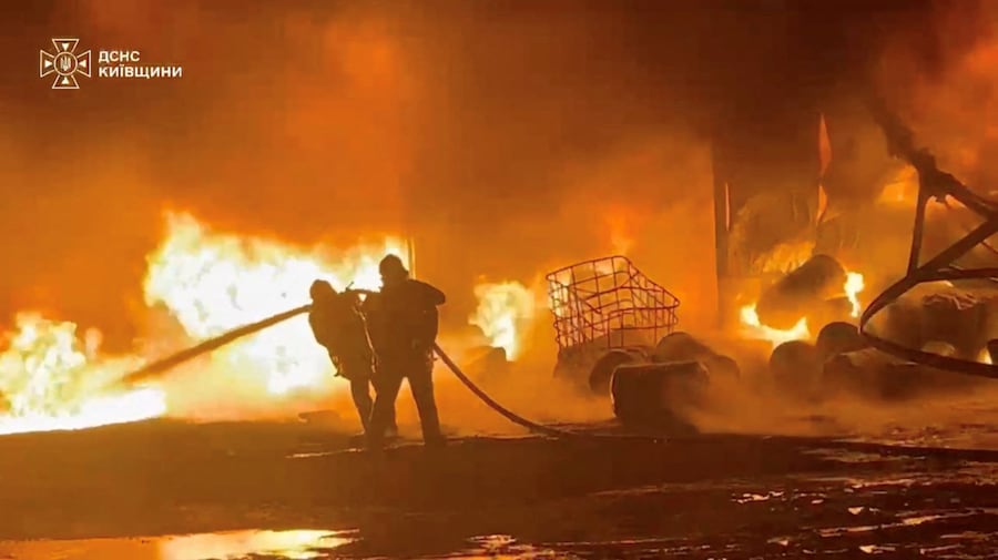 Il personale dei servizi di emergenza spegne un incendio in seguito a un presunto attacco russo contro un impianto industriale in una località indicata come il distretto di Bucha, nella regione di Kiev, in Ucraina (via REUTERS)
