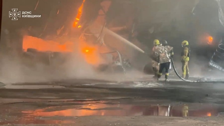 Il personale dei servizi di emergenza spegne un incendio in seguito a un presunto attacco russo contro un impianto industriale in una località indicata come il distretto di Bucha, nella regione di Kiev, in Ucraina (via REUTERS)