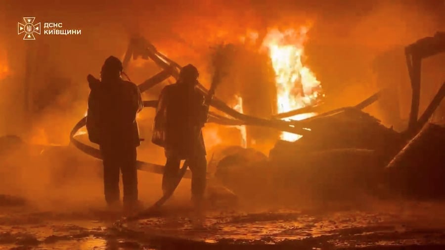 Il personale dei servizi di emergenza spegne un incendio in seguito a un presunto attacco russo contro un impianto industriale in una località indicata come il distretto di Bucha, nella regione di Kiev, in Ucraina (via REUTERS)