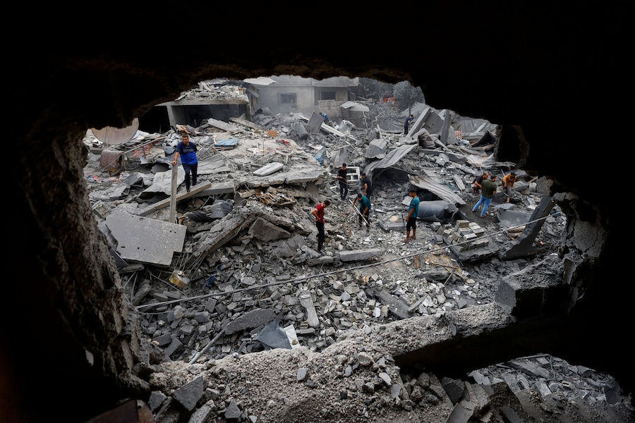 I palestinesi ispezionano il luogo in cui sorgeva un'abitazione colpita dai raid aerei israeliani, dopo che sabato in tarda serata l'esercito israeliano aveva intimato ai residenti di evacuare l'area, ad Al-Zawayda, nella Striscia di Gaza centrale, l'11 ottobre 2026. REUTERS/Mahmoud Issa (REUTERS)