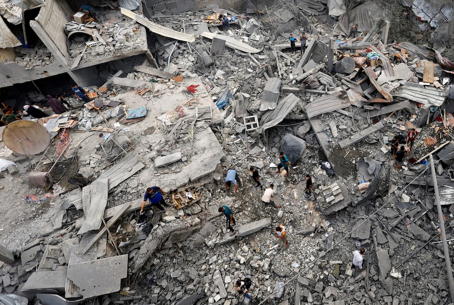 I palestinesi ispezionano il luogo in cui sorgeva un'abitazione colpita dai raid aerei israeliani, dopo che sabato in tarda serata l'esercito israeliano aveva intimato ai residenti di evacuare l'area, ad Al-Zawayda, nella Striscia di Gaza centrale, l'11 ottobre 2026. REUTERS/Mahmoud Issa (REUTERS)