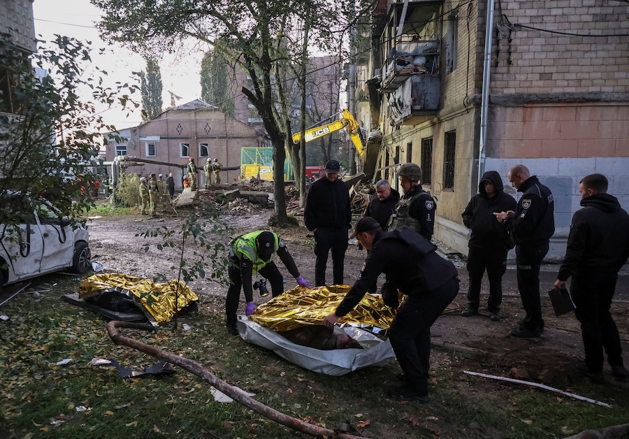 Agenti di polizia coprono il corpo di una persona uccisa, rinvenuta sotto le macerie di un condominio danneggiato durante un attacco con un drone russo a Kharkiv, Ucraina (REUTERS)