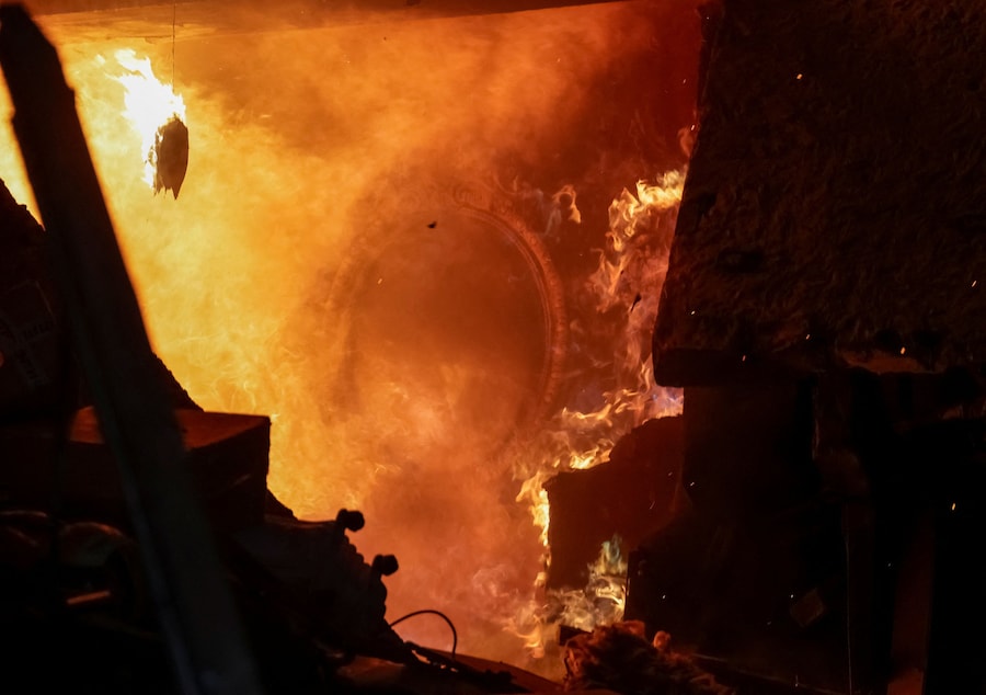 Uno specchio è appeso alla parete di un appartamento in fiamme in un condominio danneggiato durante un attacco sferrato da un drone russo a Kharkiv, Ucraina (REUTERS)