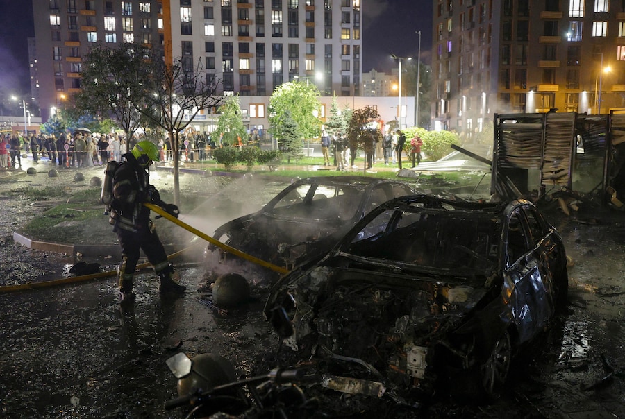 I soccorritori ucraini operano sul luogo di un attacco con droni russi contro una zona residenziale a Kiev (EPA)