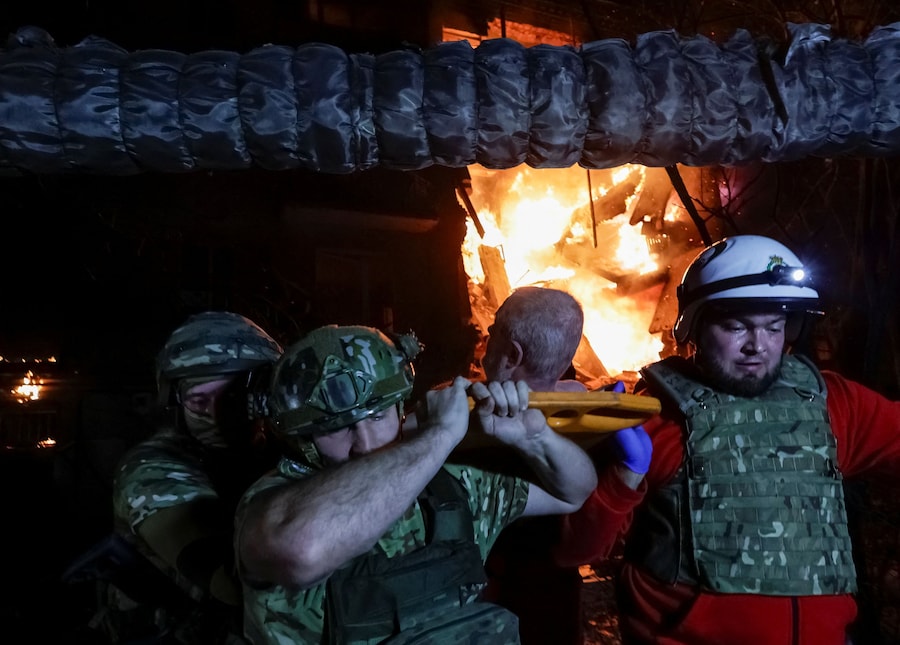 I soccorritori e il personale medico evacuano un uomo ferito rinvenuto sotto le macerie di un condominio danneggiato durante un attacco con droni russ a Kharkiv, Ucraina (REUTERS)