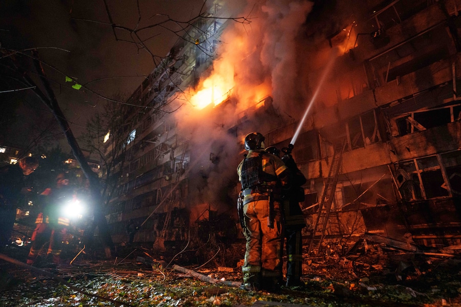 I soccorritori hanno spento un incendio divampato in un edificio residenziale a più piani danneggiato da un attacco missilistico russo a Kiev, in Ucraina (APN)