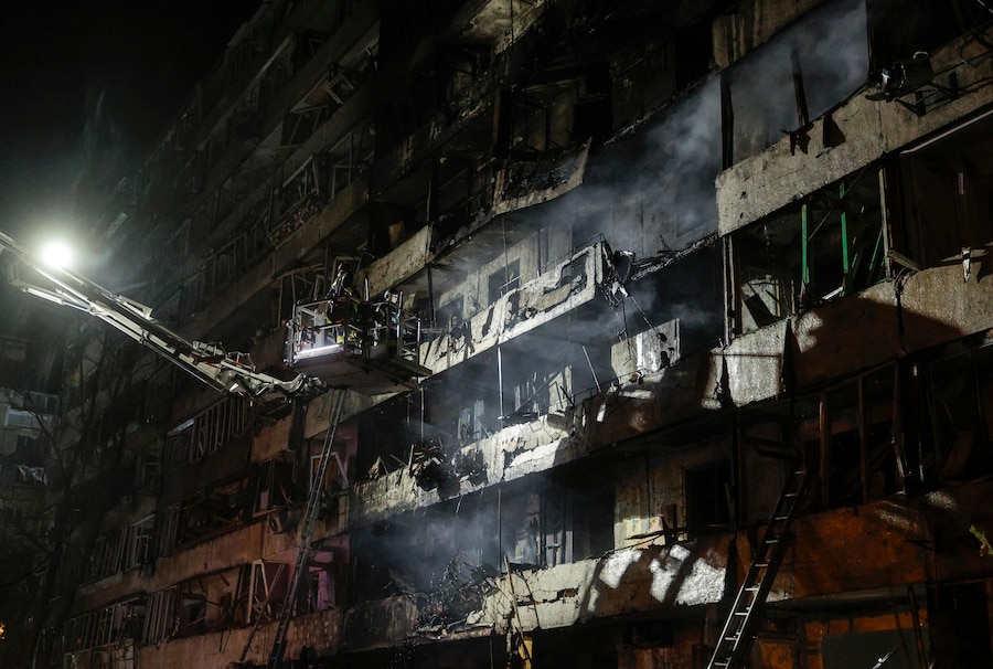 I soccorritori ucraini operano sul luogo di un attacco missilistico russo contro un edificio residenziale a Kiev (EPA)