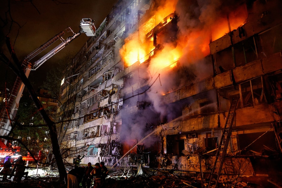 I vigili del fuoco intervengono sul luogo di un condominio danneggiato da un attacco missilistico russo a Kiev (REUTERS)