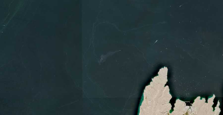 Un'immagine satellitare mostra container e oggetti che galleggiano in acqua dopo che la GFS Pride, battente bandiera di Singapore, è affondata nei pressi dello Stretto di Hormuz in seguito all'impatto con un proiettile, al largo delle coste dell'Oman, il 14 ottobre 2026. (via REUTERS)