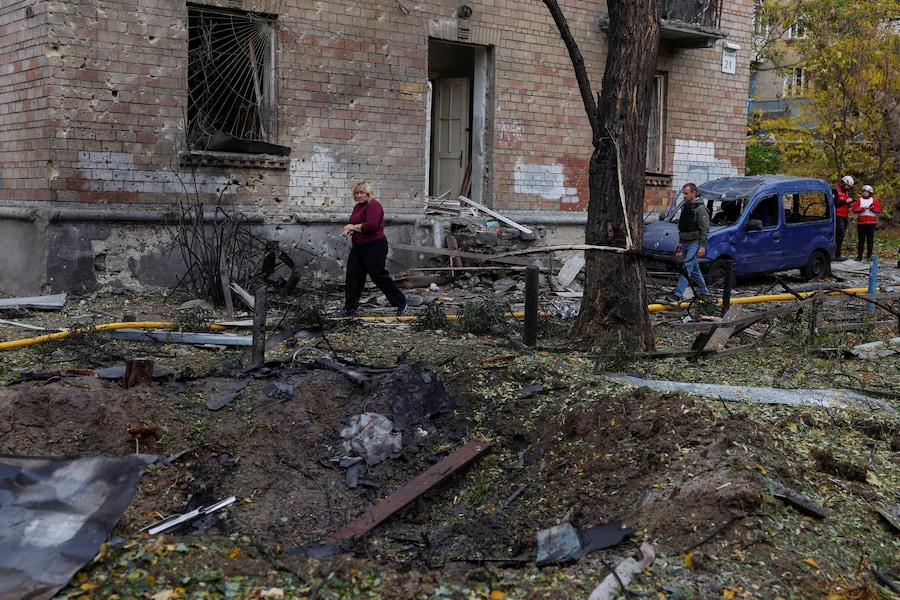 Una donna passa accanto a un cratere formatosi in una zona residenziale in seguito a un attacco con droni russi a Kiev, Ucraina (REUTERS)