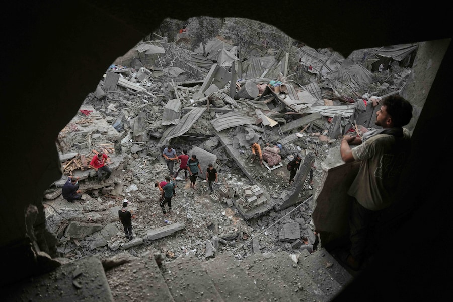 Domenica 11 ottobre 2026, alcuni palestinesi ispezionano un edificio distrutto da un attacco aereo israeliano avvenuto sabato in tarda serata a Zawaida, nella Striscia di Gaza centrale. (Foto AP/Abdel Kareem Hana) (APN)