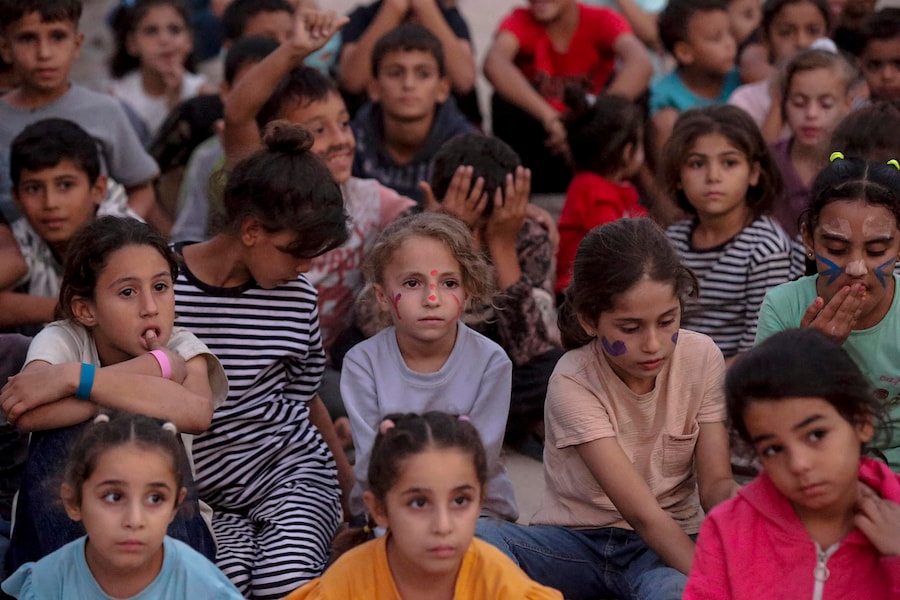 Bambini palestinesi sfollati all’interno del proprio Paese guardano un film in un cinema all’aperto improvvisato vicino alle rovine di edifici distrutti nel quartiere di Al-Sheikh Redwan a Gaza City, il 15 ottobre 2026. Secondo le Nazioni Unite, circa 1,9 milioni di persone a Gaza, quasi il 90% della popolazione, sono state sfollate dall’inizio del conflitto tra Israele e Hamas nell’ottobre 2023. EPA/MOHAMMED SABER (EPA)