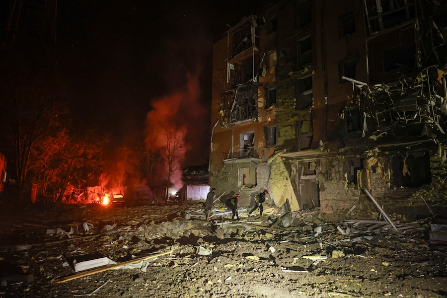 I soccorritori camminano davanti a un edificio residenziale danneggiato da un attacco aereo russo a Zaporizhzhia. (APN)