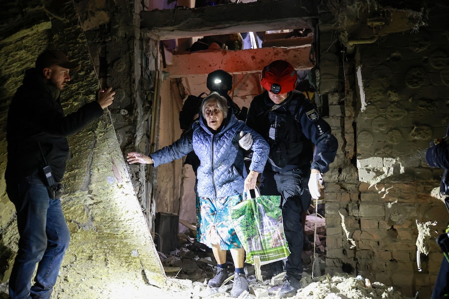 Sabato 17 ottobre 2026, a Zaporizhzhia, in Ucraina, un agente di polizia aiuta un’anziana a uscire da un edificio residenziale danneggiato da un attacco aereo russo. (APN)