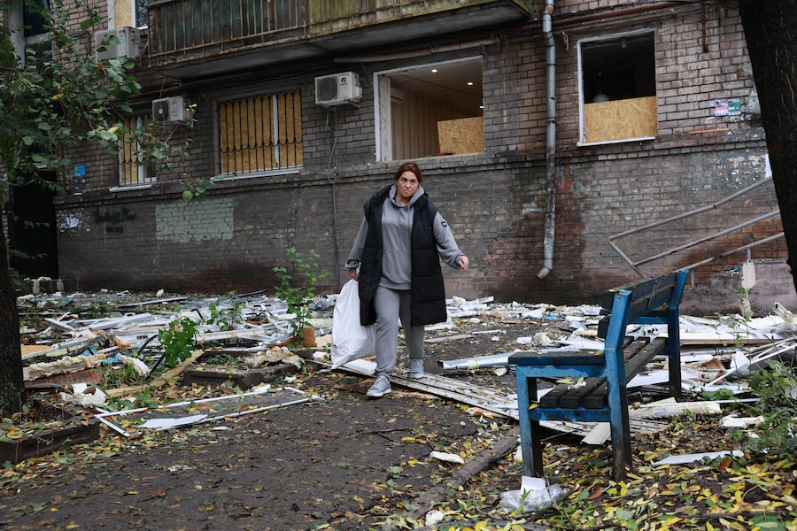 Una donna del posto porta via i propri effetti personali da un edificio residenziale danneggiato da un attacco aereo russo a Zaporizhzhia. (APN)