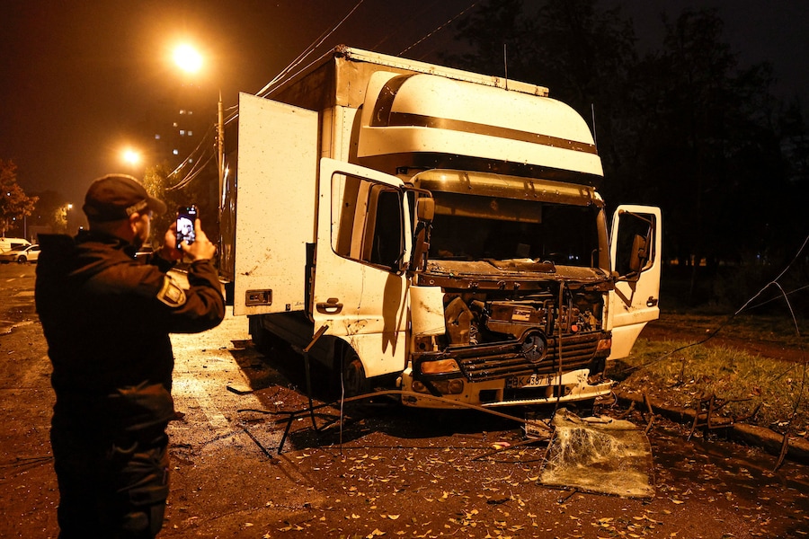 Un agente di polizia scatta una foto di un camion danneggiato in una strada a seguito di un attacco missilistico russo, nel contesto dell'offensiva russa contro l'Ucraina, a Kiev. (REUTERS)