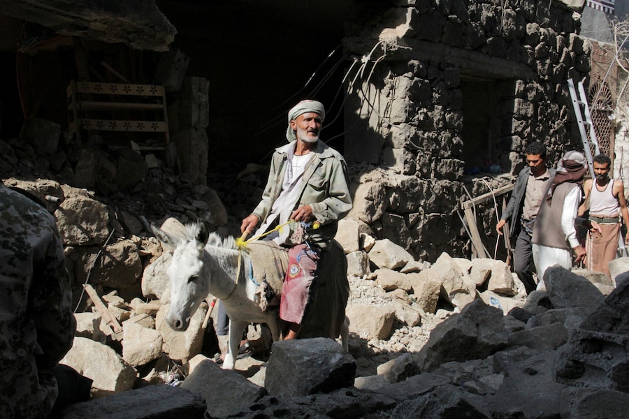 Un uomo, in sella a un asino, ispeziona i danni a un’abitazione che, secondo quanto riferito, sarebbe stata colpita da un missile degli Houthi nella città di Taiz, nel sud-ovest dello Yemen, (REUTERS)