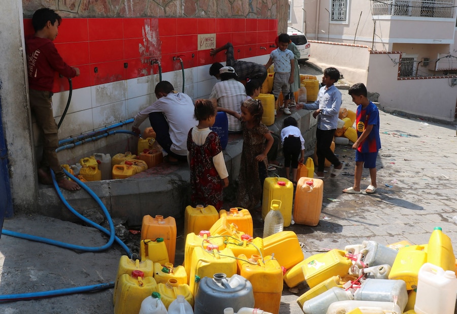 Taiz, nel sud-ovest dello Yemen, alcune persone riempiono delle taniche con acqua potabile prelevata da un serbatoio di un’organizzazione benefica (REUTERS)