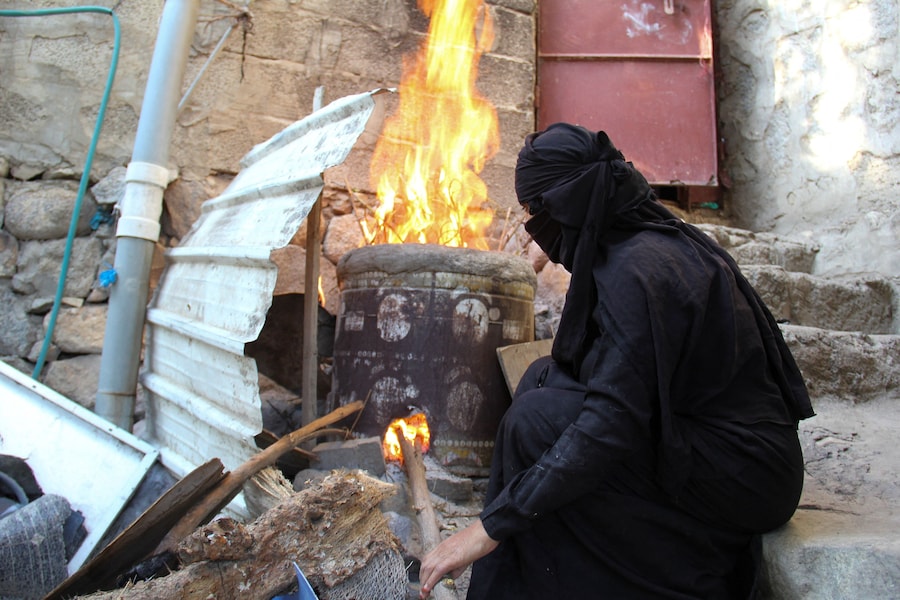 Una donna cucina in un forno a legna a causa della carenza di gas da cucina nella città di Taiz, nel sud-ovest dello Yemen (REUTERS)
