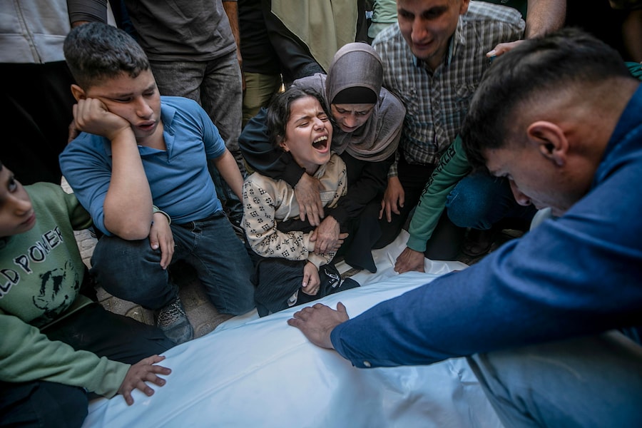 Dima, una bambina di dieci anni, figlia di Akram Yassin e Dena Abu Baker, piange davanti alle salme dei genitori all’ospedale Al-Shifa durante il loro funerale a Gaza City (EPA)