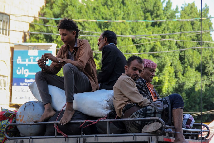 Alcune persone sono sedute sul tetto di un’auto che le sta portando fuori dalla città di Taiz, nel sud-ovest dello Yemen (REUTERS)