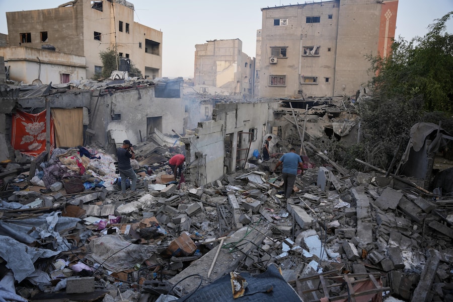 I palestinesi setacciano le macerie di un edificio distrutto durante un attacco israeliano sferrato a Nuseirat, nella Striscia di Gaza centrale (APN)