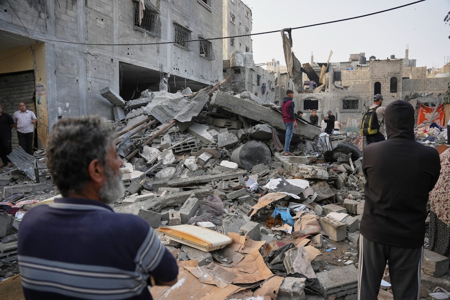 I palestinesi setacciano le macerie di un edificio distrutto durante un attacco israeliano sferrato a Nuseirat, nella Striscia di Gaza centrale (APN)